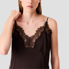 Model wearing dark brown slip camisole with deep V-neckline and delicate lace trim detailing at chest and straps