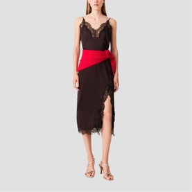 Model wearing black lace-trim cami dress with red sash wrap detail and front split, styled with gold strappy heels