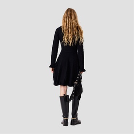 Model wearing Maje Womens French Dress in red, long-sleeve fit-and-flare style, paired with black knee-high boots, back view.