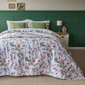 Belledorm Cleo Bedspread Multi in floral print with pink, purple and green blooms, styled on a double bed with green cushions