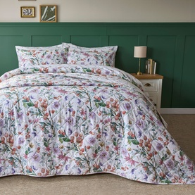 Belledorm Cleo Bedspread Multi, floral print in pink, purple and green tones on white ground, styled on a double bed with matching pillowshams