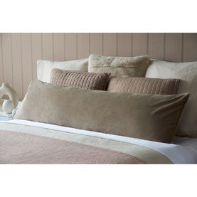 Belledorm Velvet Bolster Cushion in taupe, styled on a bed with coordinating blush and cream cushions