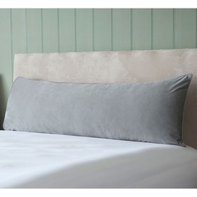 Belledorm Velvet Bolster Cushion in Cloud grey, long rectangular shape styled on a bed with white bedding