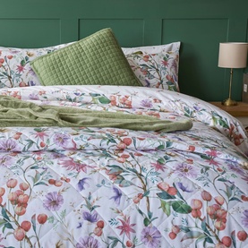 Belledorm Cleo Duvet Set Multi, white bedding with floral botanical print in pink, purple and green, styled with olive cushions