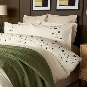 Belledorm Perth Duvet Set in ivory cotton with embroidered botanical motif border, styled with olive green quilted throw on a made bed.