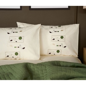 Belledorm Perth Duvet Set in ivory cotton, featuring botanical print pillowcases styled with a green quilted throw on a double bed.