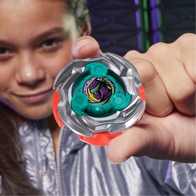 Child holding Beyblades spinning top toy in silver, teal and red multicolour with purple emblem design, shown close up