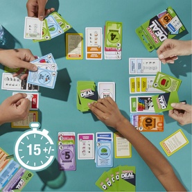 Monopoly Deal card game in play on teal surface, multiple hands reaching for colourful property and action cards, 15-minute play time shown