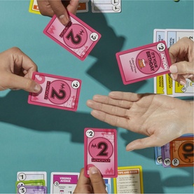 Board Games multi card game in play, showing pink numbered cards being exchanged by multiple players on teal surface