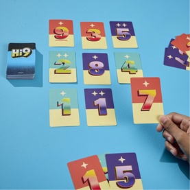 Hi9 number card game laid out on blue surface showing colourful numbered cards and card deck, hand reaching to play
