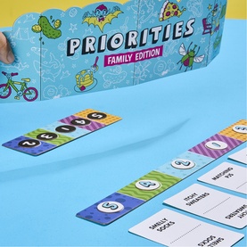 Priorities Family Edition board game laid out showing colourful ranking cards and category tiles on blue surface