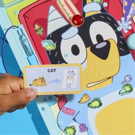 Bluey-themed Monopoly board game close-up showing character card held by child's hand, with colourful game board and pieces visible