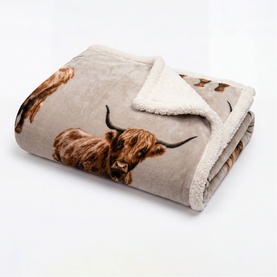 Deyongs beige sherpa throw folded, featuring Highland cow print on soft plush fabric with cream fleece reverse visible at edge.
