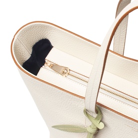 Aspinal of London ivory pebbled leather tote interior detail showing gold zip pocket and tan trim edging.