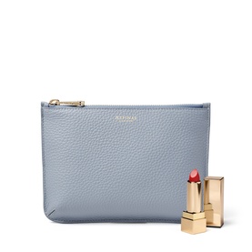 Aspinal of London Sky Blue pebbled leather pouch with gold zip, styled with a red lipstick and gold case