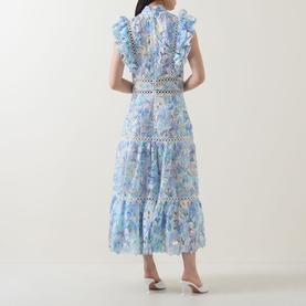 Model wearing Elliatt blue multi floral midi dress, rear view, ruffle sleeves, lace trim waist and hem, styled with white heels