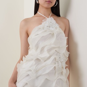 Model wearing Elliatt white halterneck mini dress with layered ruffle organza fabric and floral appliqu&eacute; detail at bust