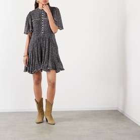Model wearing Isabel Marant Etoile black and ecru cotton mini dress with flutter sleeves and button front, styled with tan cowboy boots