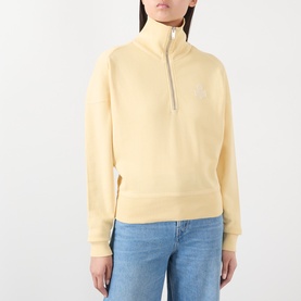 Model wearing Isabel Marant Etoile yellow half-zip sweatshirt with tonal logo embroidery, styled with blue jeans.