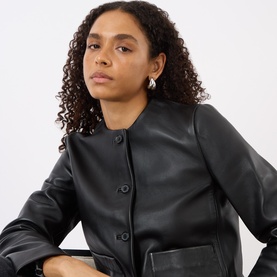 Model with Jenny Bird Orla Hoop Earrings in silver-toned polished finish, styled with a black leather collarless jacket.