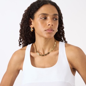 Model with Jenny Bird Rome Chain Necklace in gold, featuring square links and polished finish, styled with white tank and gold stud earrings