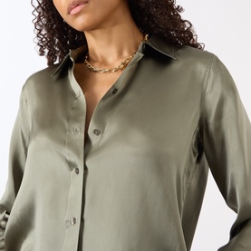 Model with Jenny Bird Art Heart Chain Necklace in gold, featuring oversized chain links and S clasp, styled with a khaki satin shirt.