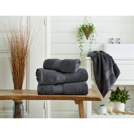 Karla Bree Portobello Towel Carbon, three folded towels stacked on wooden bench with one draped over bath, styled in bathroom setting