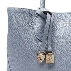 Aspinal of London Sky Blue pebbled leather tote handle detail with gold padlock charms and branded logo hardware.