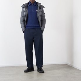 Model wearing Moncler navy wool half zip jumper, styled with grey puffer jacket and navy trousers