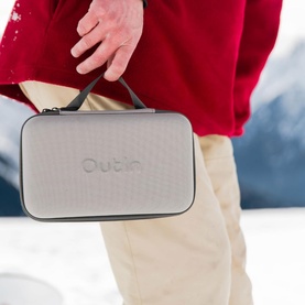 OutIn Nano Portable Espresso Machine carry case in grey, held by model outdoors in snowy setting