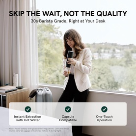 OutIn Nano Portable Espresso Machine in Forest Green, lifestyle shot showing model using device at desk near window