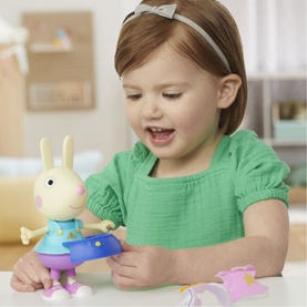 Young child playing with Peppa Pig Rebecca Rabbit figure, small multicoloured accessory pieces visible on white surface