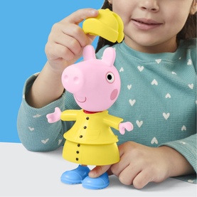 Child playing with Peppa Pig figure dressed in yellow raincoat and blue boots, with removable yellow hat accessory