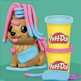 Play-Doh dog styling toy with pink and blue dough hair accessories, shown with two yellow Play-Doh compound tubs on teal background