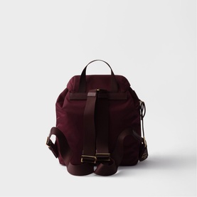 Burgundy suede backpack, rear view, with adjustable dark brown leather straps and gold-tone buckle hardware