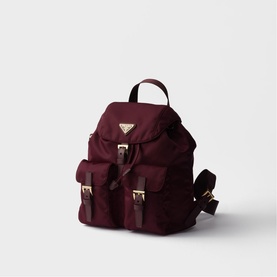 Prada burgundy nylon backpack with gold-tone hardware, front buckle pockets, triangle logo plaque, and adjustable shoulder straps