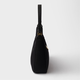Black shoulder bag with gold-tone hardware, single top handle, side profile view showing structured base and zip closure.