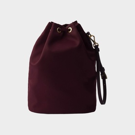 Burgundy bucket bag with drawstring top, gold-tone hardware, and detachable wrist strap