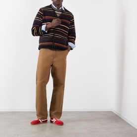 Model wearing Sacai Black Multi striped wool cardigan, styled with tan trousers, white shirt, and red trainers