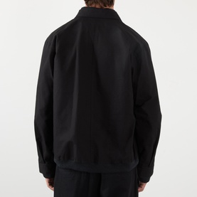 Model wearing SACAI Reversible Bomber Jacket in black, rear view showing dropped shoulders, point collar and ribbed hem.