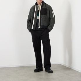 Model wearing SACAI Reversible Bomber Jacket in black, styled with black wide-leg trousers and chunky black boots