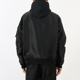 Model wearing SACAI black hoodie with nylon bomber jacket overlay, ribbed hem and cuffs, rear view showing utility pocket detail on sleeve.