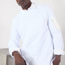 Model wearing Sacai white cotton polo shirt with zip chest pocket and rolled cuffs, mandarin collar detail
