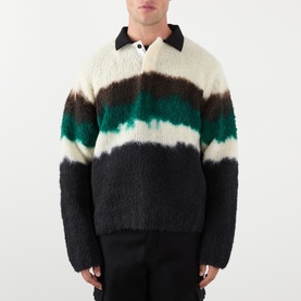 Model wearing Sacai Black Multi wool polo with abstract stripe pattern in cream, brown, green and black, with collared neckline