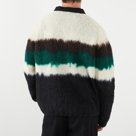 Model wearing Sacai Black Multi wool polo jumper, rear view showing colour-block stripe design in cream, green and black