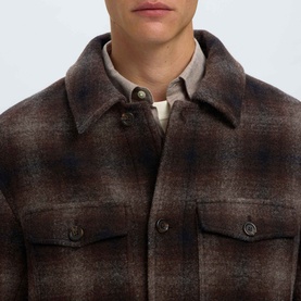 Model wearing Selected Casual Jacket in Delicioso Navy/Grey ombre plaid, with button-front chest pockets, styled over a cream shirt.