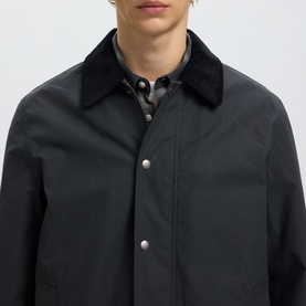 Model wearing Selected Casual Jacket in Dark Shadow, featuring corduroy collar and silver snap buttons, styled with checked shirt underneath