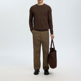 Model wearing Selected Berg Knitted Sweater in Delicioso Melange, styled with khaki trousers and carrying a dark tote bag.