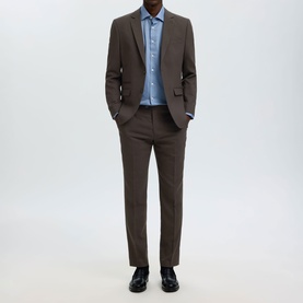 Model wearing Selected Neil Slim Single-Breasted Suit Jacket in Delicioso brown with matching trousers and light blue shirt
