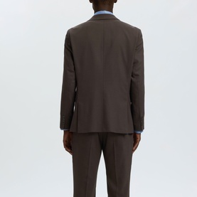 Model wearing Selected Neil Slim Single-Breasted Suit Jacket in Delicioso brown, back view, paired with matching trousers and blue shirt.
